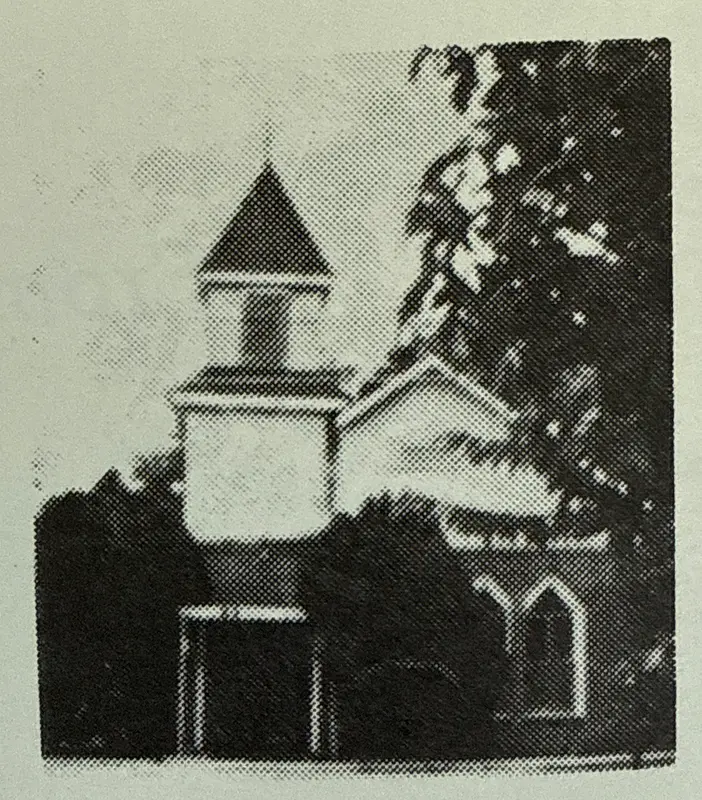 Archival photo of an early Good Hope church building with a pointed steeple and arched windows beside a large tree